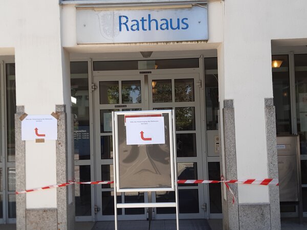 Haupteingangst�re mit rot-wei�em Flatterband und dem Hinweis 
"Bitte Nebeneingang benutzen"