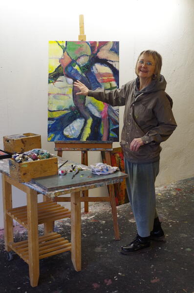 Frauke Schreiner vor einem Werk von ihr beim Malen. 